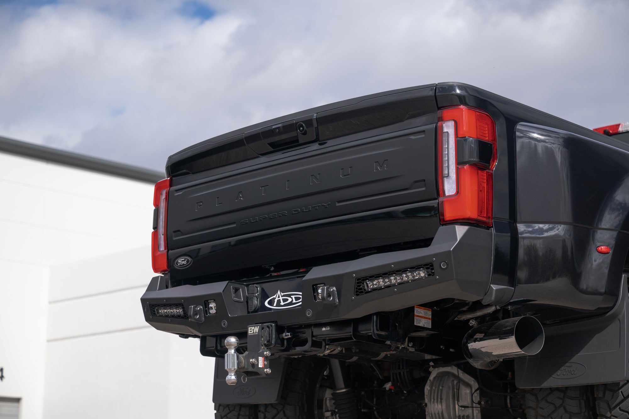 2023+ Ford Super Duty Honeybadger Rear Bumper with cloudy skies in view