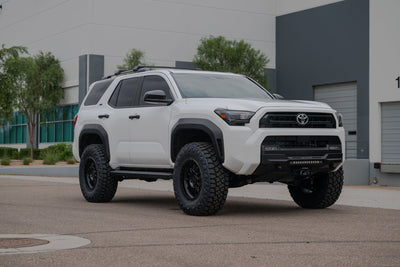 2025 Toyota 4Runner Stealth Center Mount Front Bumper with off-road modifications parked in front of a building.