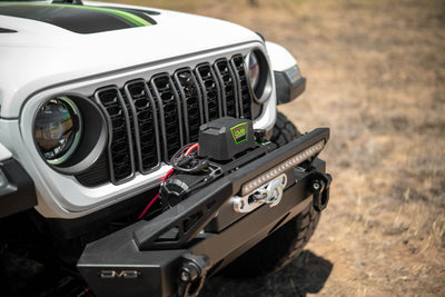 Front view of a white Jeep with DV8 Xtract 12k Synthetic Rope Winch on a natural background