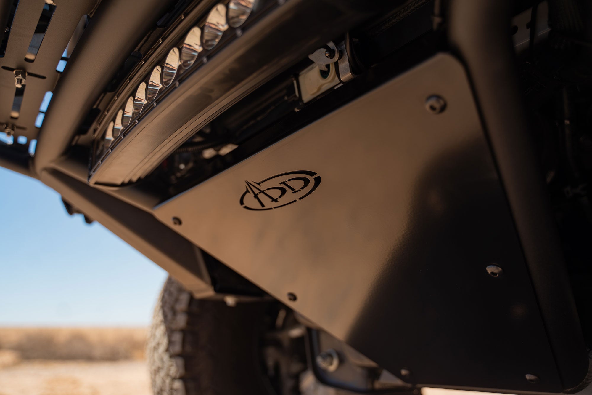 Close-up view of the integrated skid plate of the installed 2021+ Ford F-150 Raptor Pro Plus Frame Cut Front Bumper