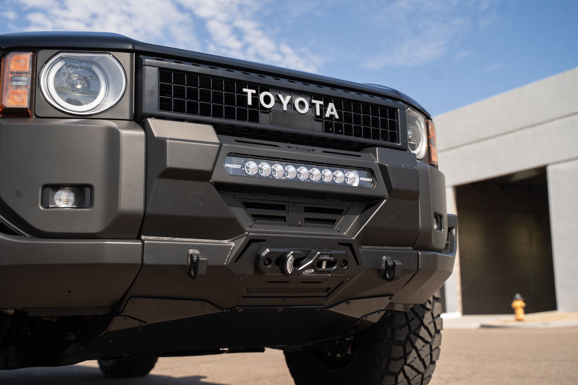 Low view of installed Toyota Land Cruiser Stealth Center Mount Winch Front Bumper for 2024 and newer vehicles with Rigid lightbar and ADD Winch fairlead