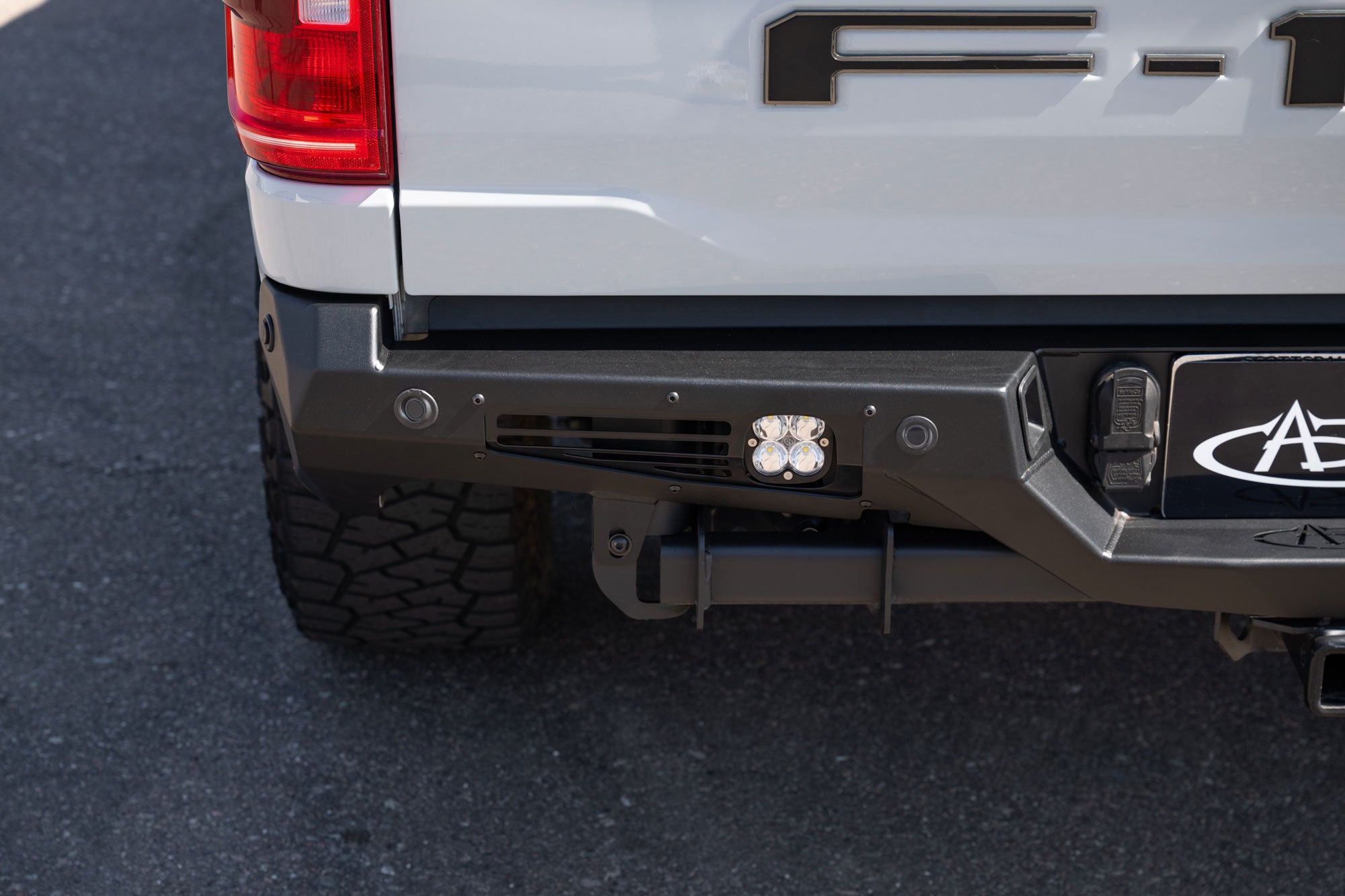 Close shot of the driver side of installed Ford F-150 Bomber Rear Bumper with Baja Designs side light installed
