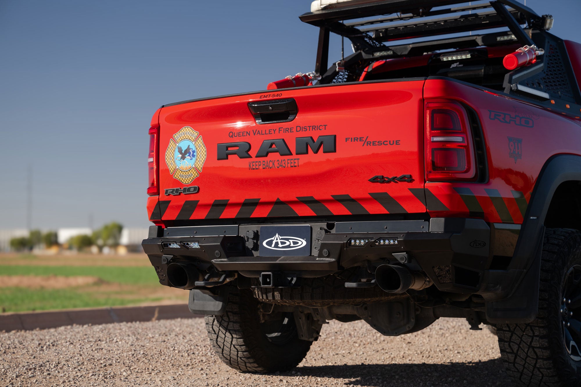 Red Ram RHO truck with Phantom Rear Bumper and emergency services branding on a gravel surface.